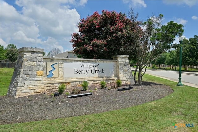 community / neighborhood sign with a lawn