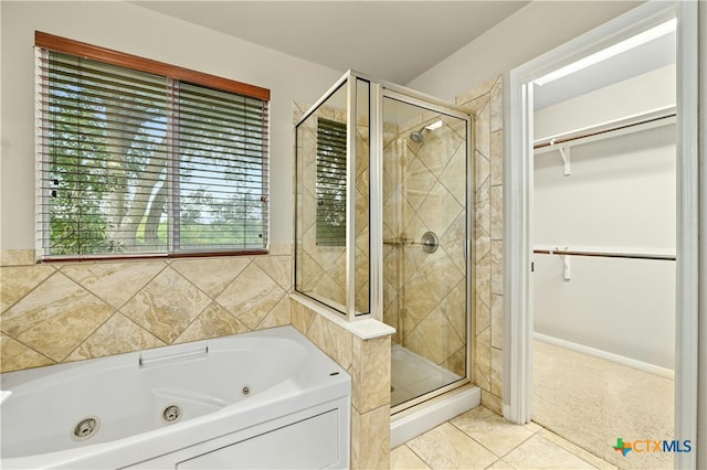 bathroom with tile patterned flooring and shower with separate bathtub