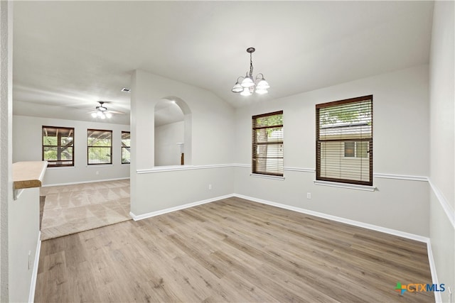 unfurnished room featuring hardwood / wood-style flooring, ceiling fan with notable chandelier, and a healthy amount of sunlight