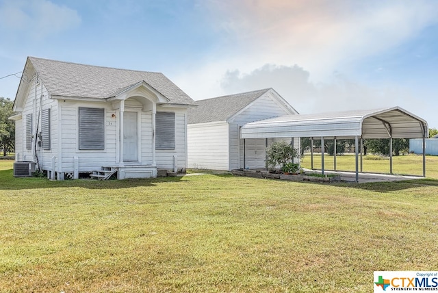 view of front facade featuring a front yard, central AC, and a carport