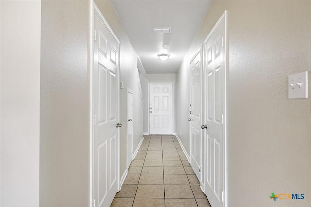 hall featuring light tile patterned floors