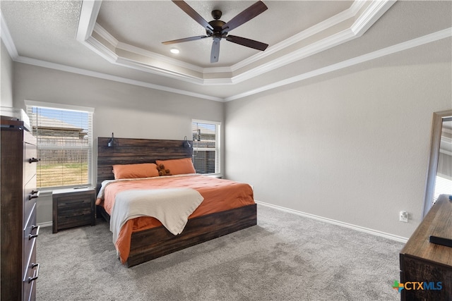 carpeted bedroom with ceiling fan, a raised ceiling, and crown molding