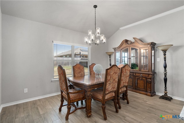 dining space featuring vaulted ceiling, light hardwood / wood-style flooring, crown molding, and a notable chandelier