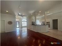 kitchen featuring open floor plan, dark wood-style flooring, and dark countertops