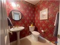 half bathroom with toilet and baseboards