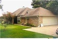 exterior space with an attached garage, concrete driveway, and a front yard