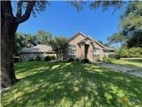 ranch-style house featuring a front lawn