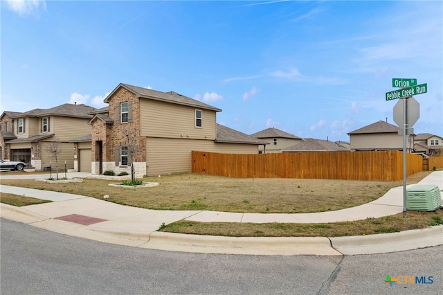 view of side of home with a residential view, stone siding, brick siding, and fence