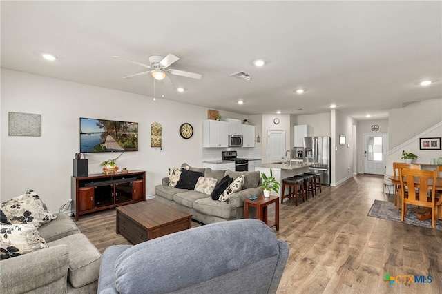 living area featuring ceiling fan, recessed lighting, visible vents, baseboards, and light wood-type flooring