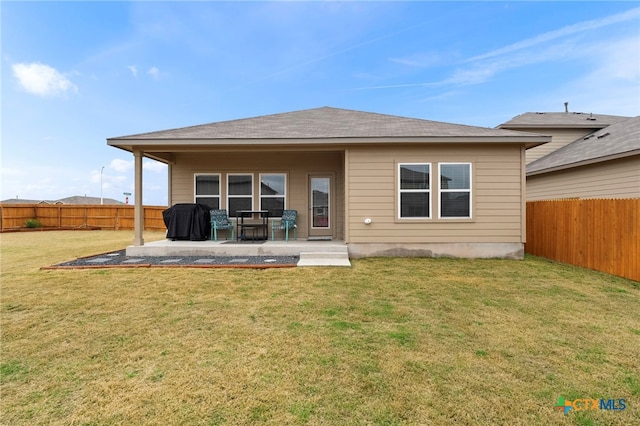 rear view of property featuring a lawn, a patio area, and a fenced backyard