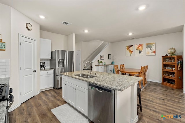 kitchen with appliances with stainless steel finishes, dark wood-style flooring, a sink, and visible vents