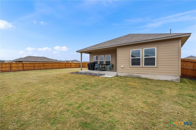 rear view of house featuring a yard, a patio area, and a fenced backyard