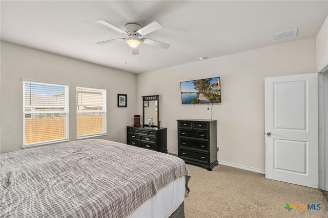 bedroom with light carpet, ceiling fan, visible vents, and baseboards