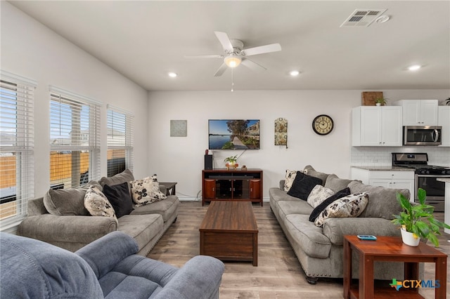 living area featuring visible vents, baseboards, light wood-style flooring, ceiling fan, and recessed lighting