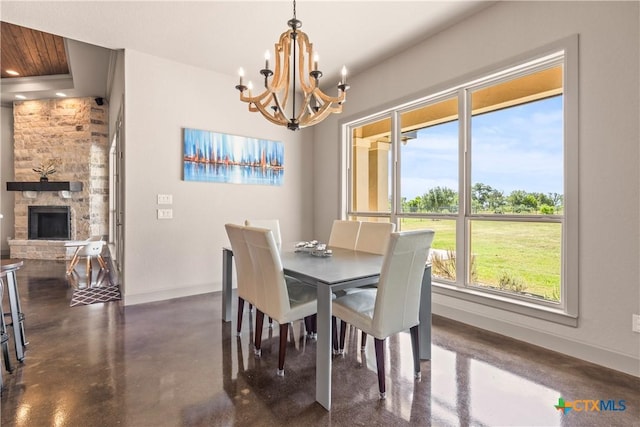 2718 Beaver Ln, New Braunfels, TX 78132 - dining area featuring a notable chandelier, finished concrete flooring, recessed lighting, a stone fireplace, and baseboards