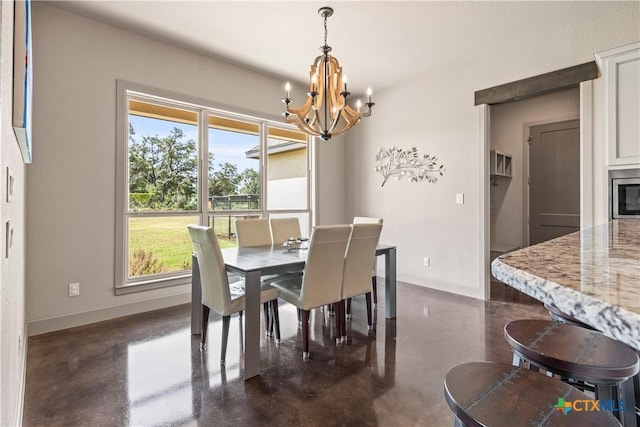 2718 Beaver Ln, New Braunfels, TX 78132 - dining room with a chandelier, concrete floors, and baseboards