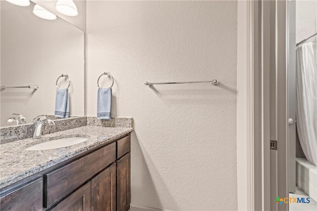 2718 Beaver Ln, New Braunfels, TX 78132 - full bathroom with vanity, a shower with shower curtain, and a textured wall