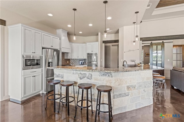 2718 Beaver Ln, New Braunfels, TX 78132 - kitchen featuring decorative backsplash, a kitchen breakfast bar, light stone counters, and appliances with stainless steel finishes