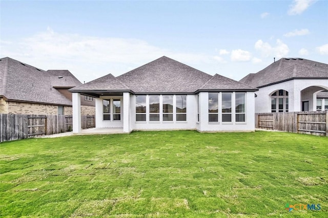 back of house with a yard and a patio