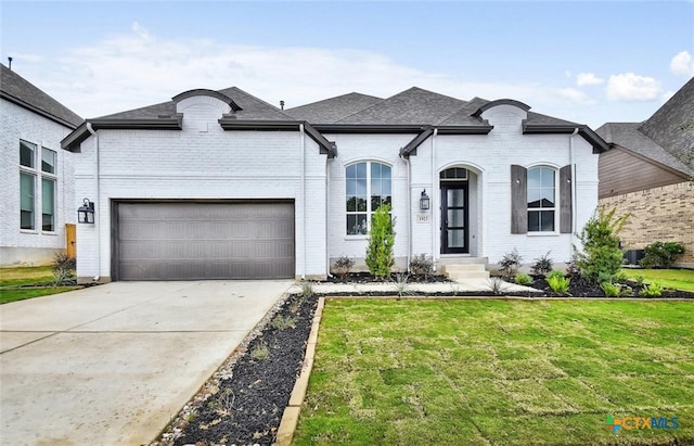 french country inspired facade featuring a front yard and a garage