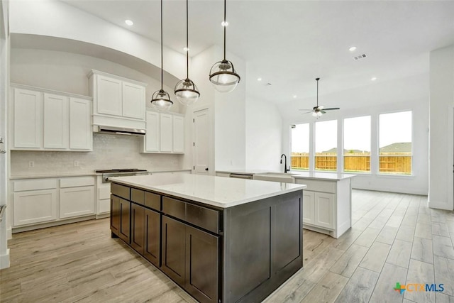 kitchen featuring pendant lighting, a center island, white cabinetry, and ceiling fan