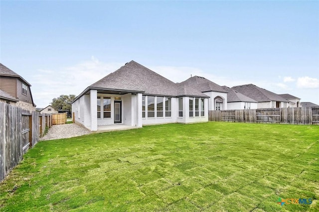 back of house with a lawn and a patio area