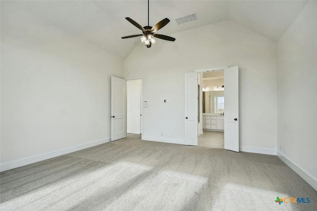 unfurnished bedroom featuring light carpet, high vaulted ceiling, ensuite bath, and ceiling fan