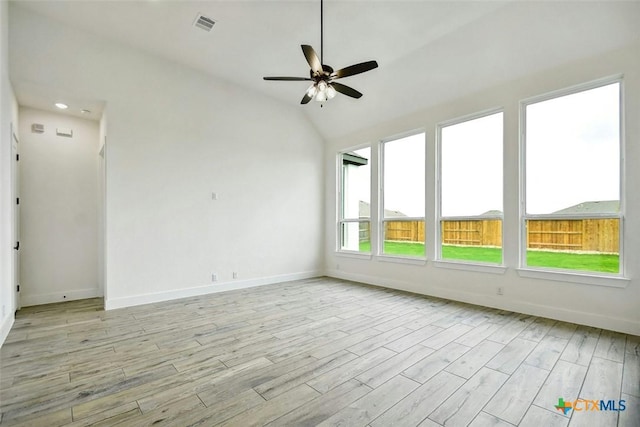 unfurnished room with a wealth of natural light, light wood-type flooring, vaulted ceiling, and ceiling fan