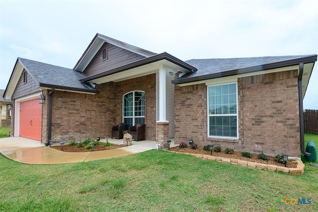 view of front of house with a front lawn, a shingled roof, brick siding, and a garage