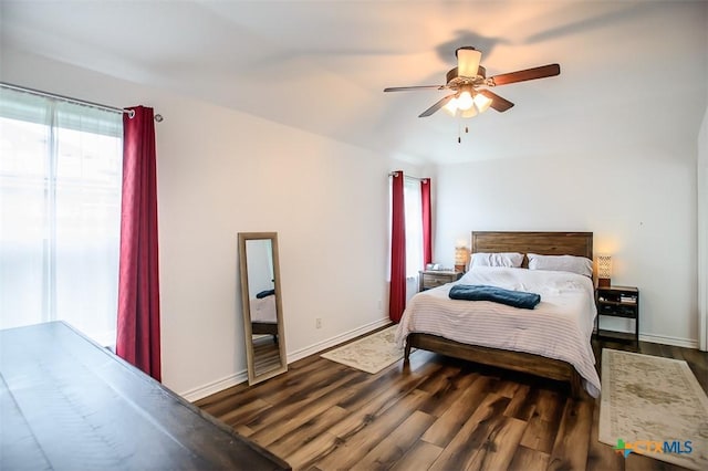 bedroom featuring wood finished floors, baseboards, a ceiling fan, and multiple windows