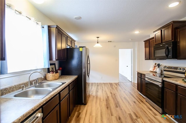 7202 Bose Ikard Dr, Killeen, TX 76549 - kitchen with appliances with stainless steel finishes, dark brown cabinets, light wood finished floors, light countertops, and recessed lighting