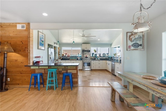 kitchen featuring sink, stainless steel appliances, white cabinets, and light hardwood / wood-style floors