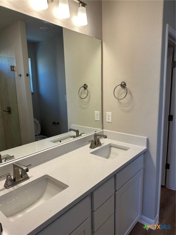 bathroom with vanity, a shower, hardwood / wood-style floors, and toilet