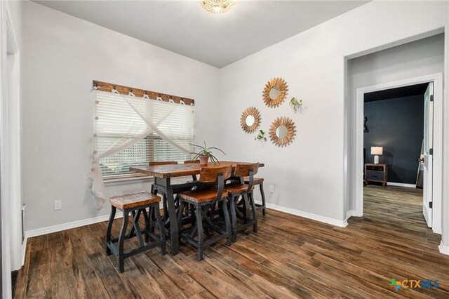 dining room featuring dark wood-type flooring and baseboards