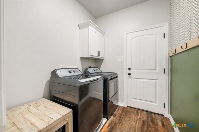 laundry area with cabinet space, dark wood finished floors, washer and clothes dryer, and baseboards