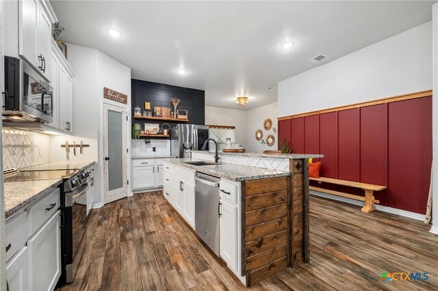 kitchen featuring dark wood-style flooring, visible vents, stainless steel appliances, and a sink