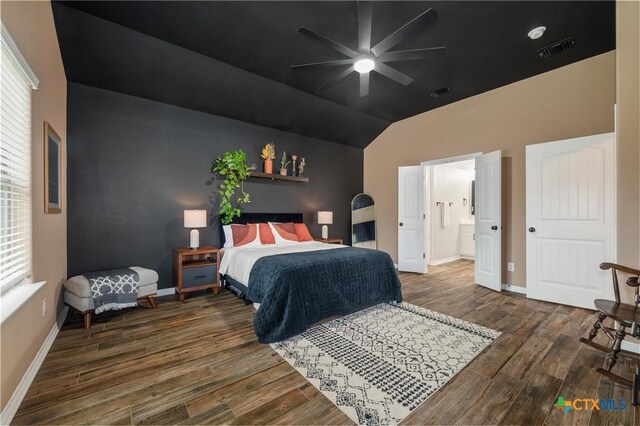 bedroom with visible vents, connected bathroom, baseboards, and wood finished floors