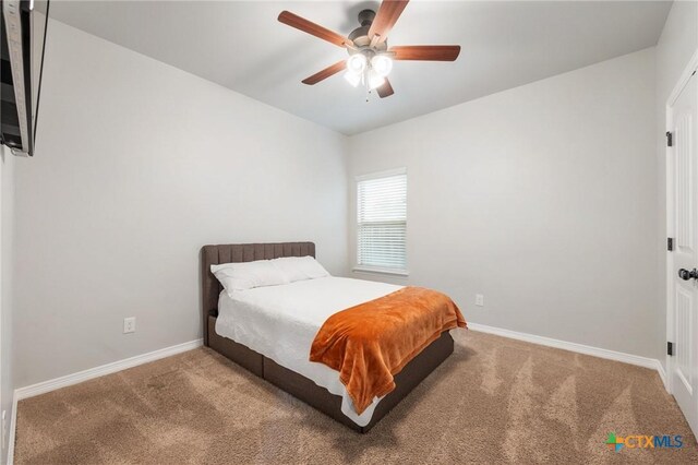 carpeted bedroom featuring a ceiling fan and baseboards