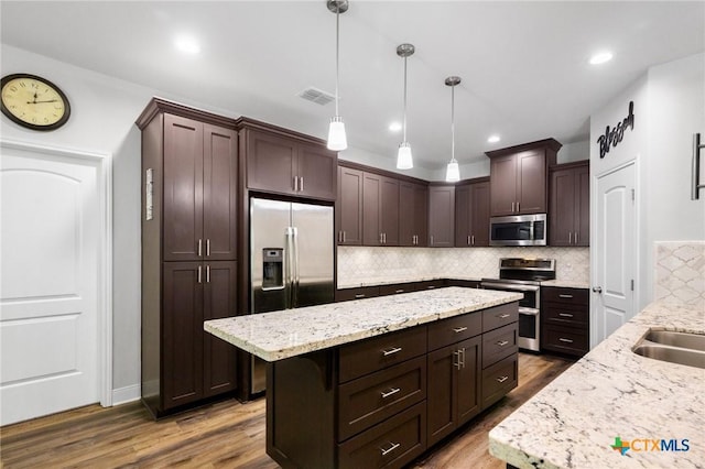 267 Oak View Dr, Inez, TX 77968 - kitchen with stainless steel appliances, a center island, dark brown cabinetry, wood finished floors, and recessed lighting