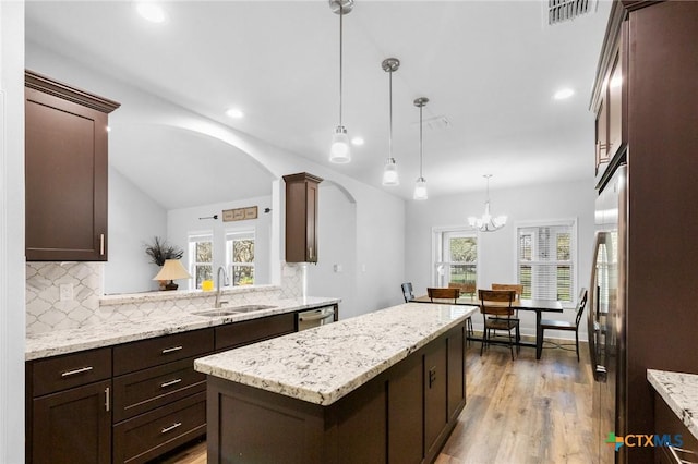 267 Oak View Dr, Inez, TX 77968 - kitchen featuring a sink, a center island, arched walkways, backsplash, and healthy amount of natural light