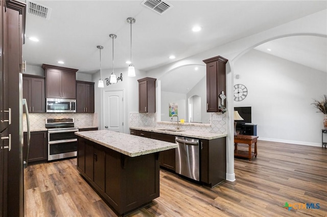 267 Oak View Dr, Inez, TX 77968 - kitchen with stainless steel appliances, a center island, dark brown cabinets, a sink, and tasteful backsplash
