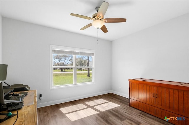 267 Oak View Dr, Inez, TX 77968 - unfurnished bedroom featuring wood finished floors, baseboards, ceiling fan, and an office area