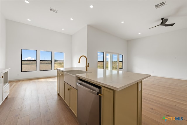 kitchen featuring dishwasher, sink, an island with sink, ceiling fan, and light wood-type flooring