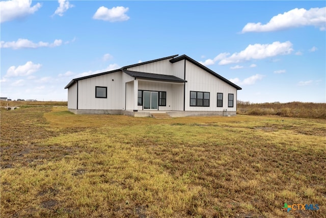 rear view of property with a lawn