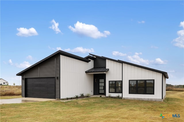 modern farmhouse featuring a front yard and a garage