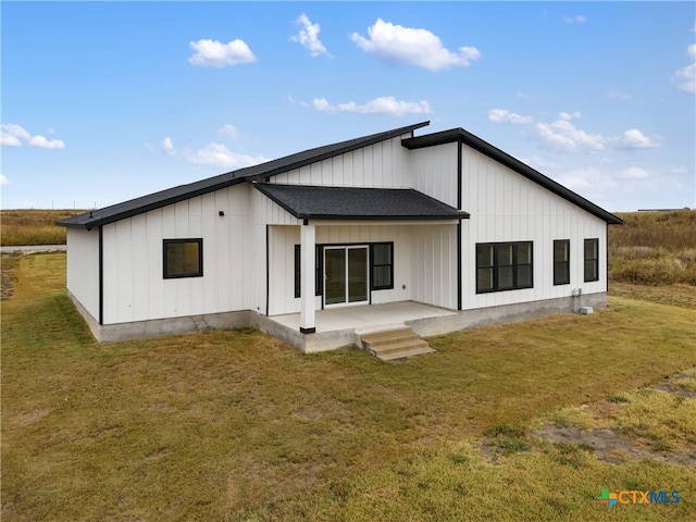 rear view of property featuring a lawn and a patio area