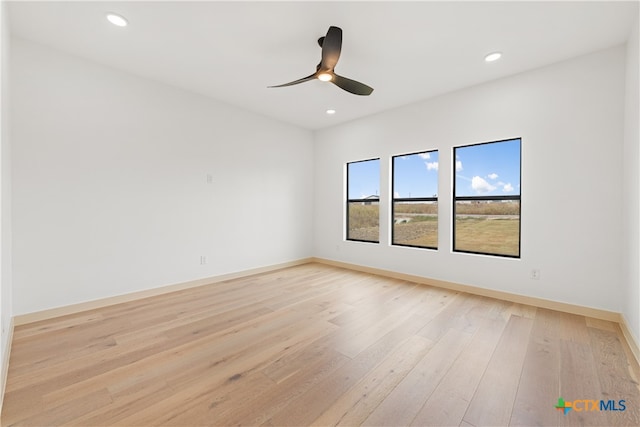 spare room with light wood-type flooring and ceiling fan