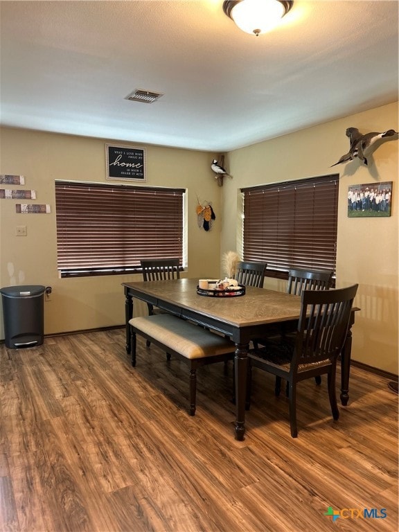 dining space with wood-type flooring