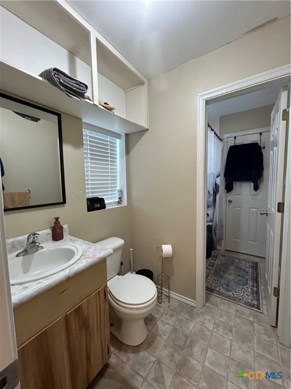 bathroom featuring curtained shower, vanity, and toilet