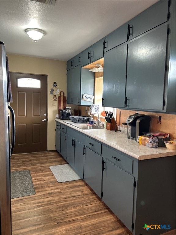 kitchen with stainless steel refrigerator, dark hardwood / wood-style flooring, and sink